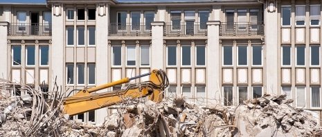 Un escavatore demolisce uno stabile